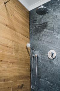 a shower in a bathroom with a wooden floor at Voronet Noir Chalet in Voronet