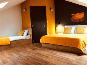 a bedroom with two beds with yellow walls and wooden floors at Urban Corner - Deluxe Apartments in Bitola