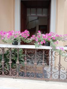 un balcone con fiori rosa su una ringhiera di Dimora LUCILLA a Ponti Sul Mincio