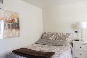 a bedroom with a bed and a painting on the wall at Le Marigot in Vaudreuil-Dorion