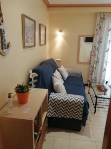 Una sala de estar con un sofá azul y una mesa. en Fuengirola Apartamento vacacional MEDITERRANEO REAL, en Fuengirola 10 fotos más