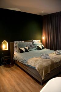 a bedroom with a large bed with a green wall at Bed and Breakfast in de buurt in Waalwijk