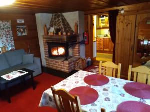 a living room with a table and a fireplace at Mysig stuga i Vasaloppsbyn Evertsberg in Älvdalen