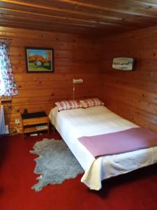 a bedroom with a bed in a wooden room at Mysig stuga i Vasaloppsbyn Evertsberg in Älvdalen