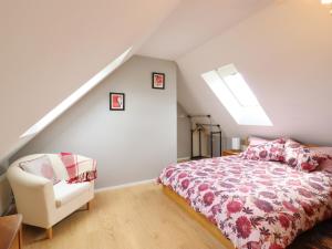 a bedroom with a bed and a chair at The Studio in Astwick