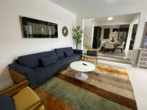 Una sala de estar con un sofá azul y una mesa. en Pousada Casa da Praia, en São Francisco do Sul