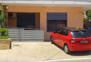 a red car parked in front of a house at SUNFLOWER in Agia Galini