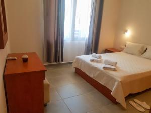 a bedroom with a bed and a table and a window at SUNFLOWER in Agia Galini