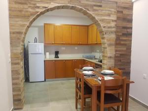 an archway in a kitchen with a table and a refrigerator at SUNFLOWER in Agia Galini +5 photos
