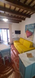 un soggiorno con divano giallo e tavolo di FioreMare a Castellammare del Golfo