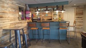a bar in a restaurant with wooden walls and stools at Peacock Lake Glamping in Nottingham