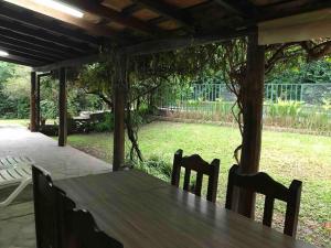 una mesa de madera y sillas bajo una pérgola en Lindísima casa de campo en Villa San Lorenzo Salta en San Lorenzo