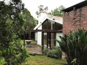 聖洛倫索的住宿－Lindísima casa de campo en Villa San Lorenzo Salta，一座带玻璃窗的房子和砖砌建筑