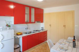 ツァヴタットにあるMAZZA House Cavtat with Sea view-Centerの赤いキャビネットと白い冷蔵庫のあるキッチン +27枚の写真