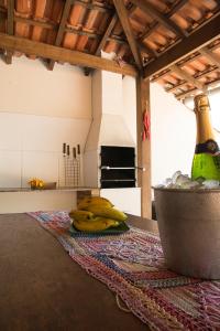 un mucchio di banane su un tavolo con una bottiglia di vino di Trindade Hospeda -Casa 1- Você a Varanda e o Mar a Trindade