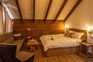 ein Schlafzimmer mit einem Bett, einem Sofa und einem Stuhl in der Unterkunft ארואד סוויטס Arwad suites in Madschdal Schams