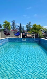 una piscina con suelo de baldosa azul y un tobogán en Tornado Hotel, en Ureki