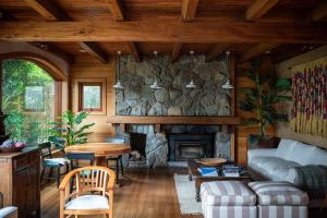 a living room with a stone fireplace and a table at Hotel Puelche in Puerto Varas