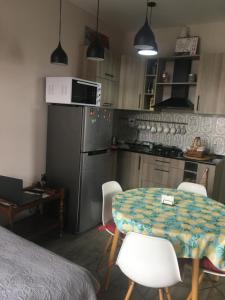 a kitchen with a table and a kitchen with a refrigerator at Great view apartment near Piazza Batumi in Batumi