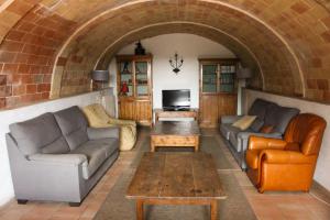 Sala de estar con 2 sofás y mesa en Mas Goy, casa rural con piscina, en Girona