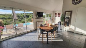 a dining room with a table and chairs and a kitchen at Les Terrasses du Cap in Le Marin