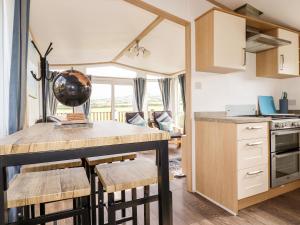 a kitchen with a table and chairs in a room at Orchard View in Tintagel