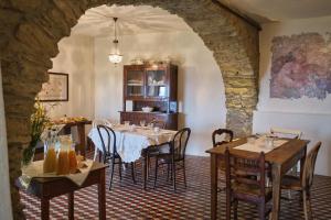 a dining room with tables and chairs and an archway at Agriturismo Le Merline in Arnasco