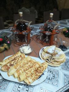 - une table avec des assiettes de nourriture et des bouteilles de vin dans l'établissement Casa Gemenelor, à Cluj-Napoca