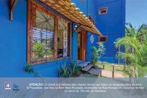 a blue house with a front door and a window at i9 Quixaba Flat in Itacaré