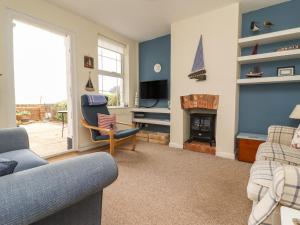 ein Wohnzimmer mit einem Sofa und einem Kamin in der Unterkunft 9 Harefield Cottages in Exmouth
