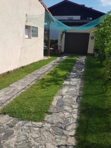 a stone walkway leading to a house with a tent at Charming house "Luisi" in green garden Maribor 75m2 in Maribor