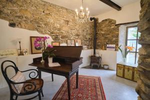 Habitación con piano, mesa y sillas en Agriturismo Le Merline en Arnasco