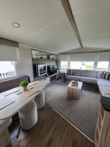 ein Wohnzimmer mit einem Sofa und einem Tisch in der Unterkunft Seton Sands Holiday Home in Port Seton