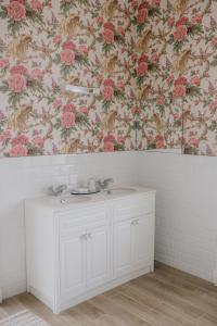 baño con lavabo blanco y papel pintado con motivos florales en Noan Country House B&B en Cashel