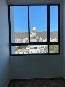 a window in a room with a view of a city at Fabuloso apartamento en el Mar Caribe - Rodadero in Gaira