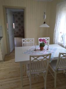 a dining room with a white table and chairs at Lodge åstön in Söråker