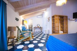 a bedroom with a blue bed and checkered floor at Suitetti Camere&Relax in San Nicola Arcella