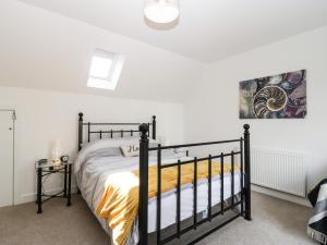 a bedroom with a black bed and a painting on the wall at 9 Mitchell Gardens in Axminster