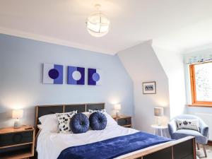 a bedroom with a large bed with blue pillows at Silver Birch Lodge in Kintail +24 photos