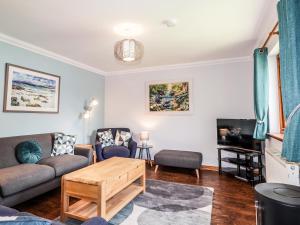 a living room with a couch and a table at Silver Birch Lodge in Kintail