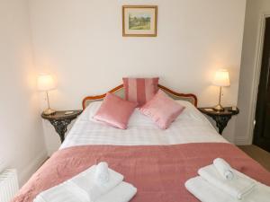 una camera da letto con un letto con asciugamani rosa e bianchi di Kirkham House a Matlock