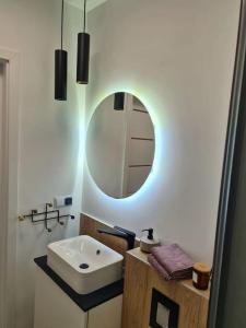 a bathroom with a sink and a mirror at Uroczy apartament blisko centrum - 10 min do plaży in Gdynia