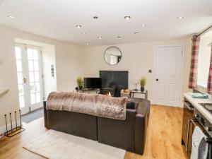 a living room with a brown leather couch at Polgowan Barn in Thornhill