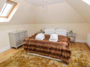 a bedroom with a large bed with two towels on it at Polgowan Barn in Thornhill