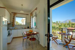 a kitchen with a table and chairs and a balcony at Liakas Village in Spartià