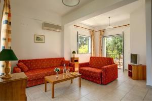 a living room with two red couches and a table at Liakas Village in Spartià