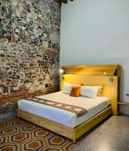 a bed in a room with a brick wall at 107 SUITES DONCELES CENTRO HISTÓRICO CDMX in Mexico City