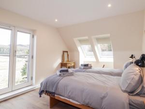 a white bedroom with a bed and a window at Westertown in Strathdon