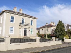 une maison blanche avec une clôture devant dans l'établissement Beachcomber, à Ballycastle
