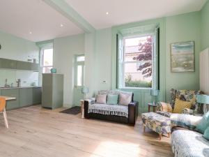 un salon avec deux canapés et une cuisine dans l'établissement Beachcomber, à Ballycastle